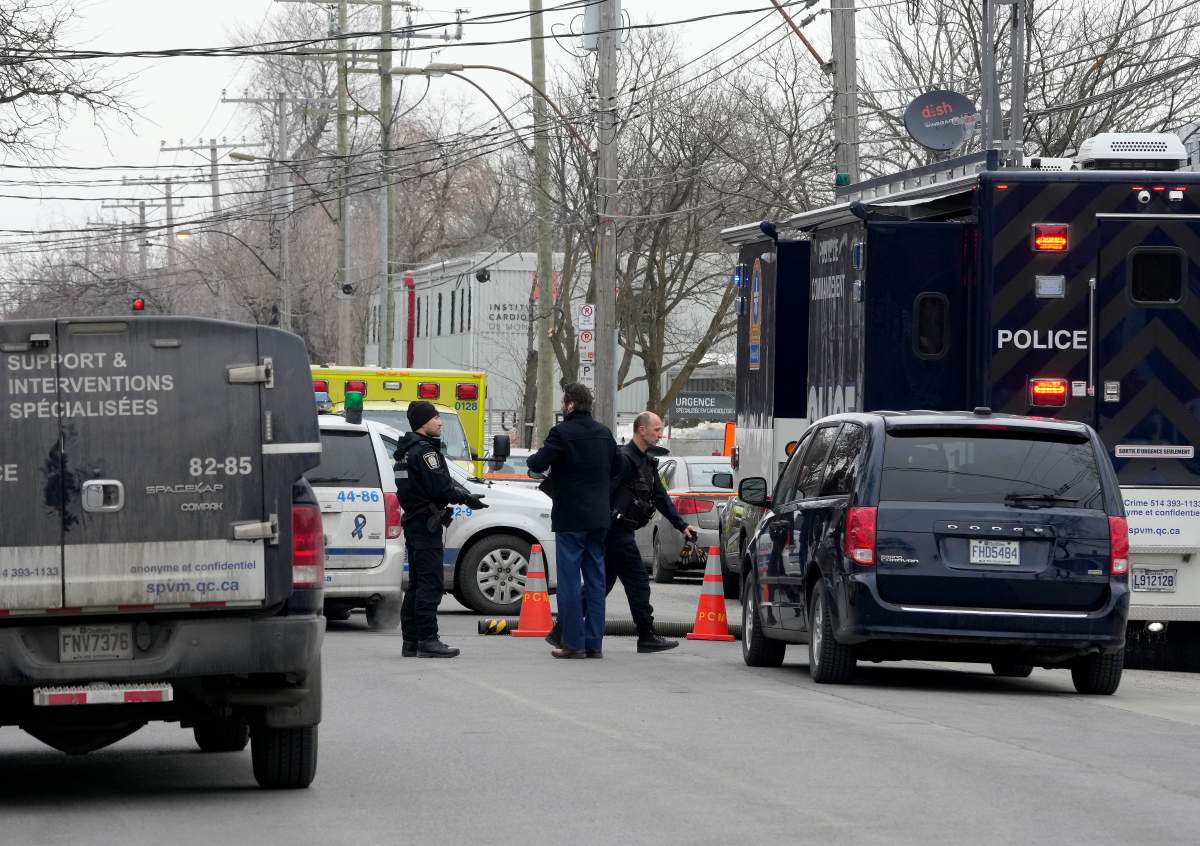 Montreal police attend the scene of a triple stabbing, in Montreal, Friday, March 17, 2023. Montreal police say a suspect is under arrest after three people were found stabbed to death inside an east-end Montreal apartment.