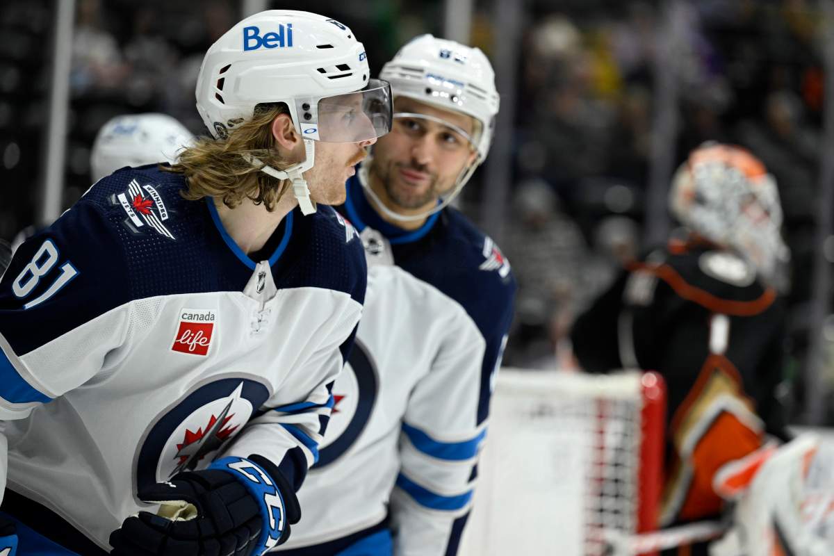 Winnipeg Jets left wing Kyle Connor, left, reacts after scoring against Anaheim Ducks goaltender Lukas Dostal, right, with right wing Nino Niederreiter, center, looking on during the second period of an NHL hockey game in Anaheim, Calif., Thursday, March 23, 2023.