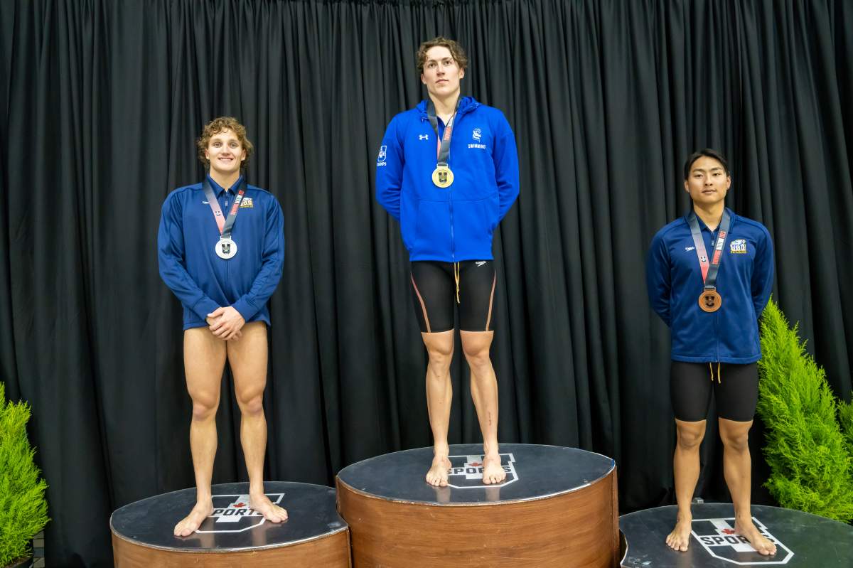 Lethbridge Pronghorns swimmer Chris Alexander stands atop the U Sports Swimming Championships podium. Alexander won gold in the 50-metre backstroke, less than four years after sustaining a serious foot injury.
