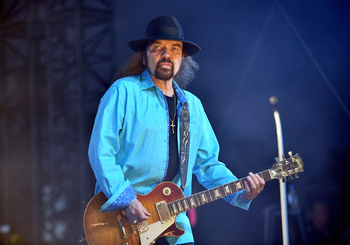 Gary Rossington playing guitar on stage.