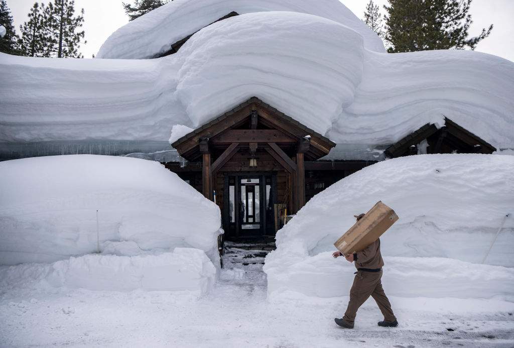 UPS delivery driver Juan Hernandez delivers a package to a snow-covered home in Truckee, California on March 03, 2023.