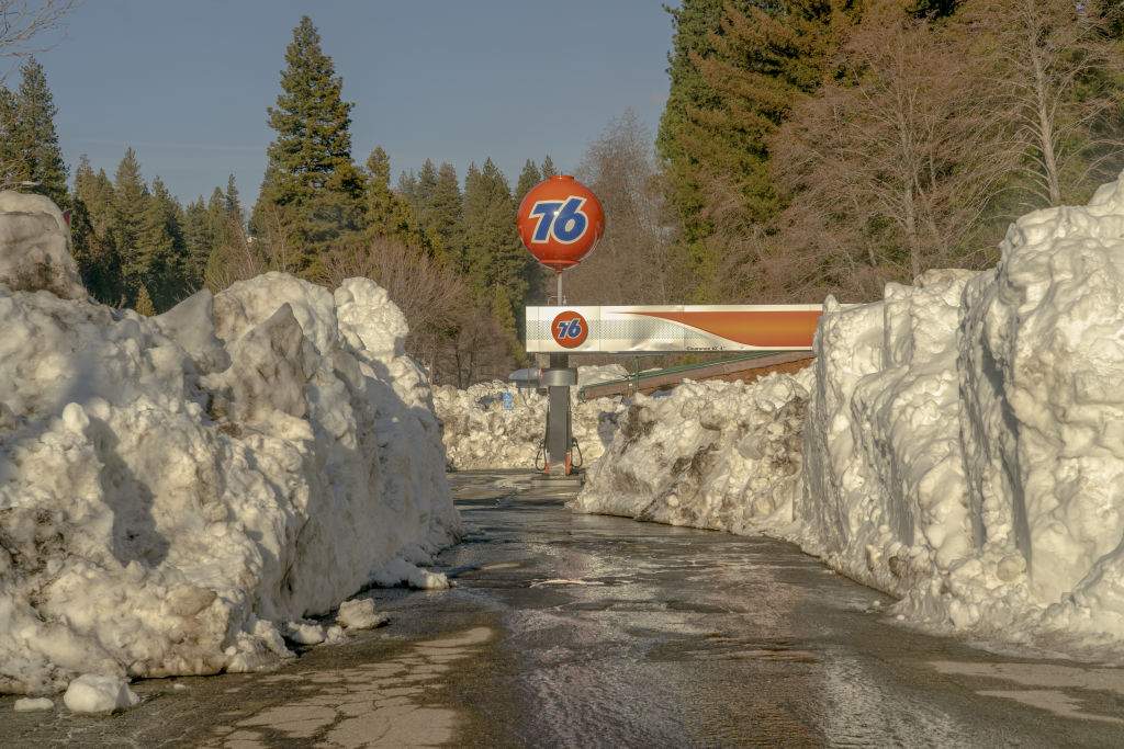 Snow piled around a 76 gas station in Lake Arrowhead, California, US, on Tuesday, March 7, 2023.