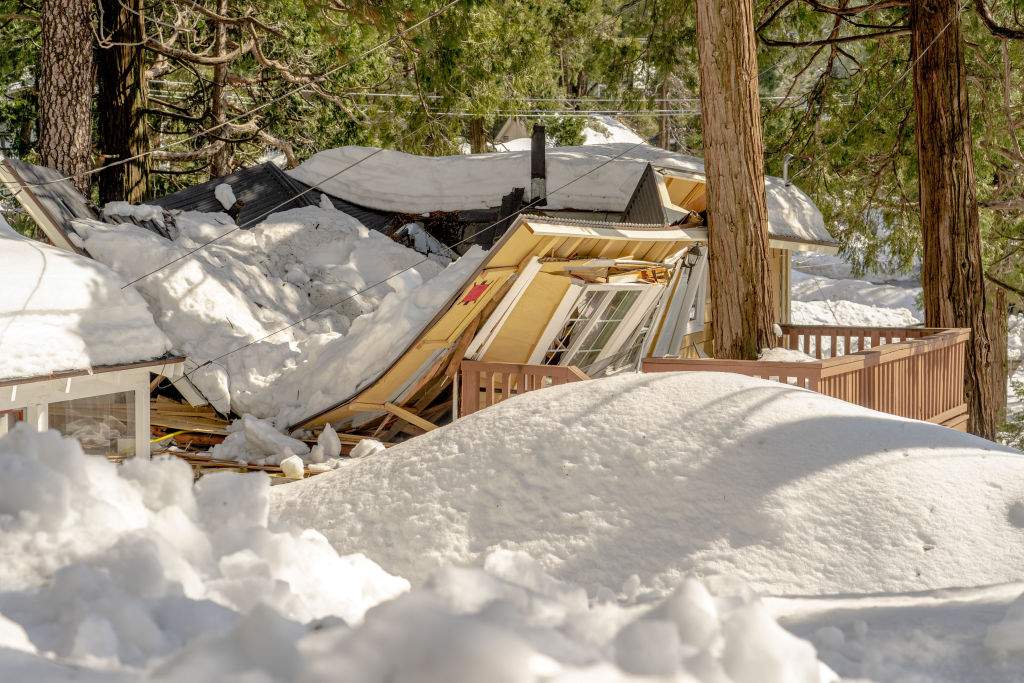 A house with a caved in roof in Crestline, California, US, on Tuesday, March 7, 2023.