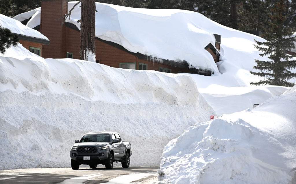 A vehicle makes its way along Lakeview Blvd. in Mammoth Mountain Tuesday. Over 550 inches of snow has fallen at the main lodge as residents try to dig out.