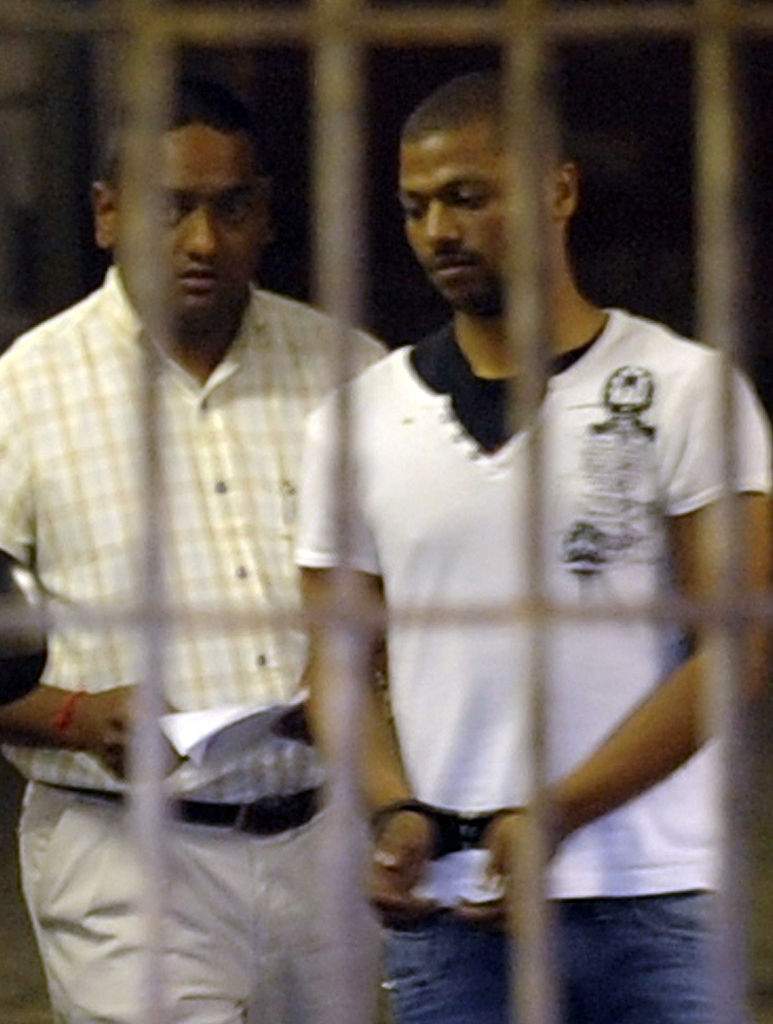 Detective Warrant Officer Shane Naidoo leads Thabo Bester out of the holding cells at the Durban Magistrates Court on October 12, 2011 in Durban, South Africa.