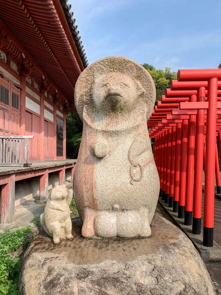 Stone statues depicting "tanuki" or raccoon dogs stand on the grounds of Yashima-ji, Temple 84 of the Shikoku 88 Buddhist temple pilgrimage, on November 11, 2019 near the town of Takamatsu in Kagawa Prefecture on the island of Shikoku, Japan.