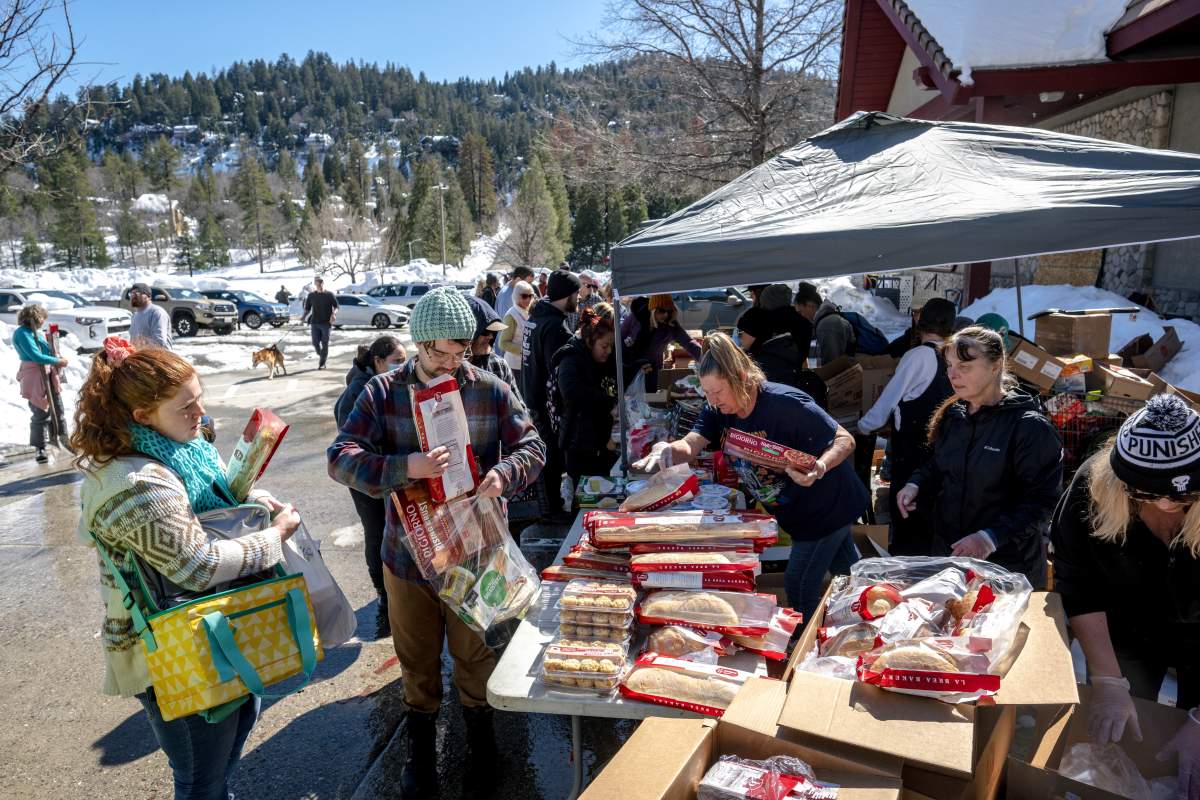 People line up for food in a community cut off by the California snow storm