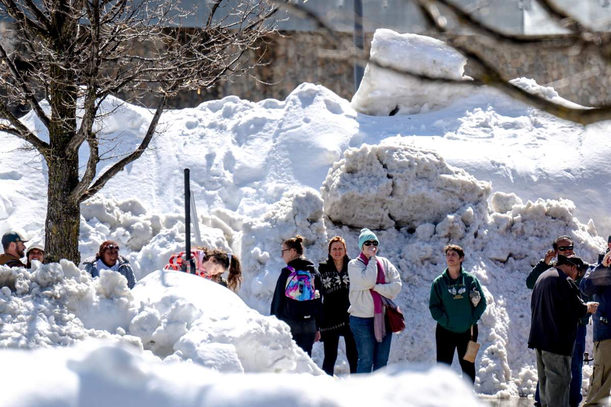 People wait in long lines for food in communities cut off in the California snow storms.