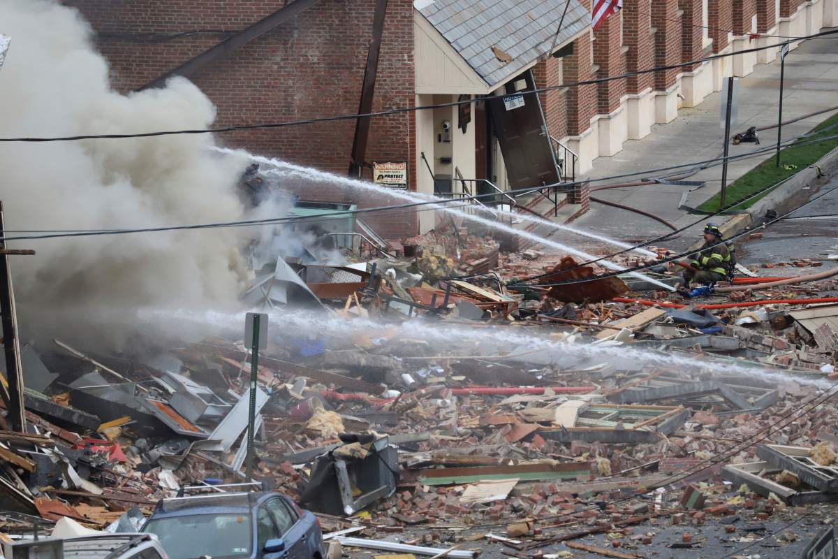 Emergency personnel work at the site of a deadly explosion at a chocolate factory