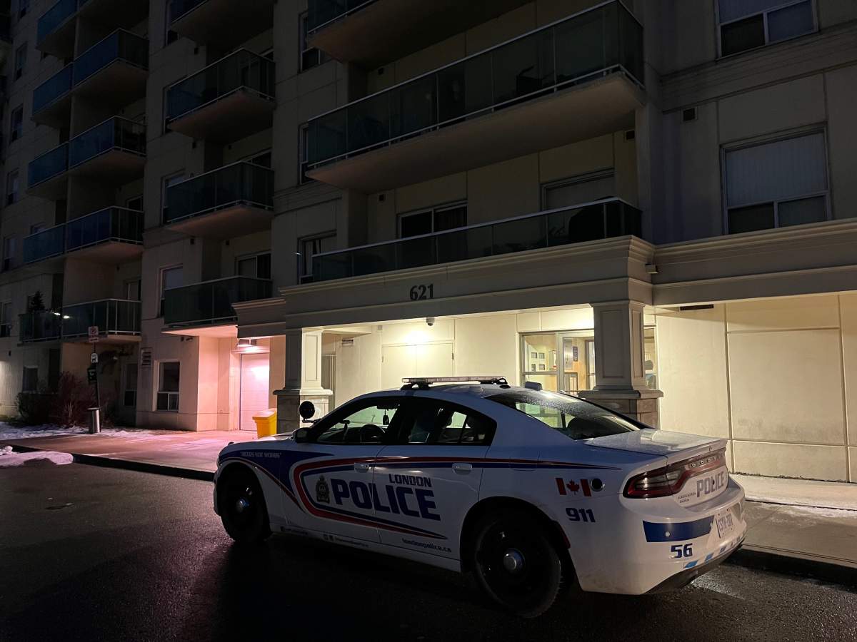 A London police cruiser outside the front of an apartment building at night.