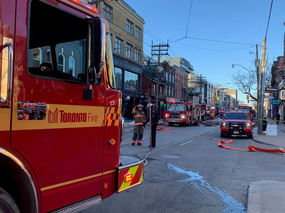 Firefighters at the scene of a fire on Queen Street West, near Augusta Avenue, on March 15, 2023.