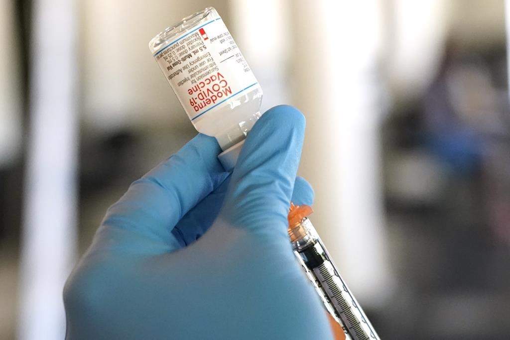 File photo. A nurse loads a syringe with the Moderna COVID-19 vaccine at an inoculation station. 
