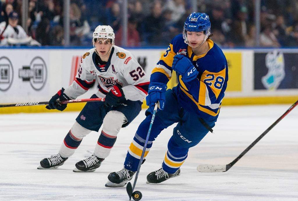 Saskatoon Blades forward Lukas Hansen (28) skates with the puck during the third period of WHL playoff hockey action against Regina Pats in Saskatoon, Sask., on Friday, March 31, 2023. THE CANADIAN PRESS/Heywood Yu.