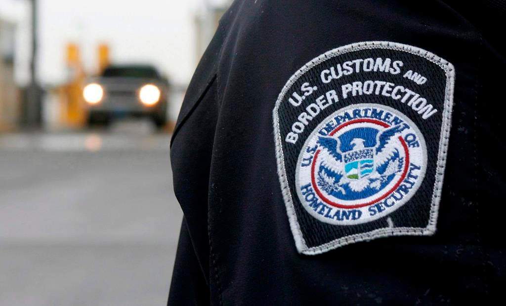A U.S. Customs and Border Protection officer stands near a security booth as vehicles approach in Detroit, Mich, on Monday, June 1, 2009. U.S. officials say at least seven of the nine men caught crossing the border from Canada this week in southeast Manitoba are Mexican citizens. THE CANADIAN PRESS/Dave Chidley.