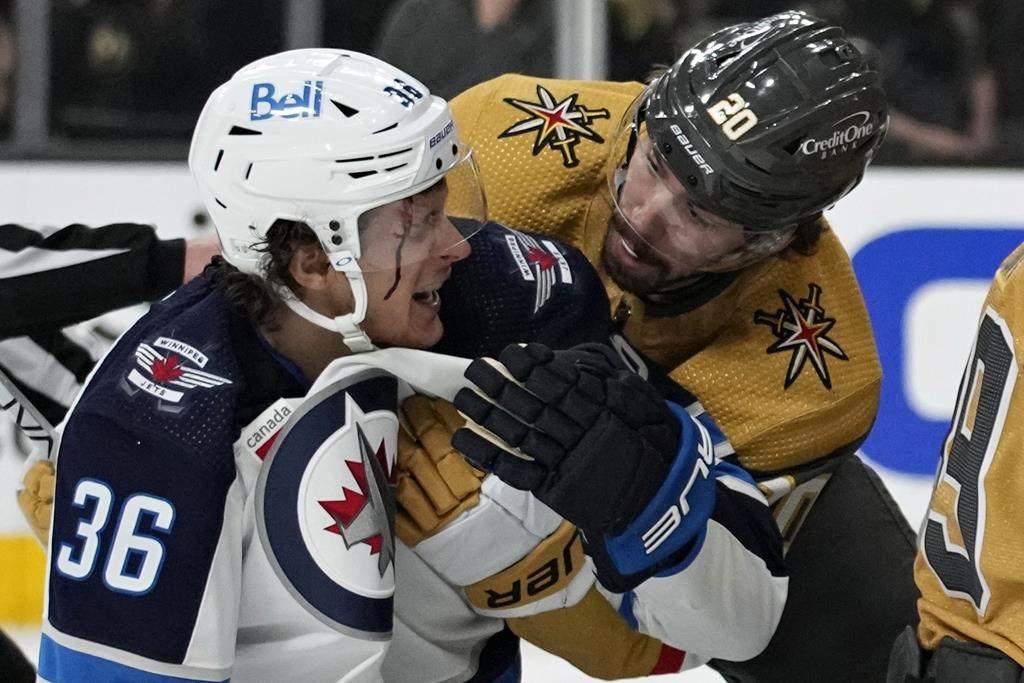 Vegas Golden Knights centre Chandler Stephenson (20) helps Winnipeg Jets center Morgan Barron (36) after Barron cut his face on a skate during the first period of Game 1 of an NHL hockey Stanley Cup first-round playoff series on April 18 in Las Vegas. (AP Photo/John Locher)
