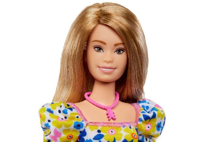 A Barbie doll with Down syndrome with light brown hair and wearing a colourful dress