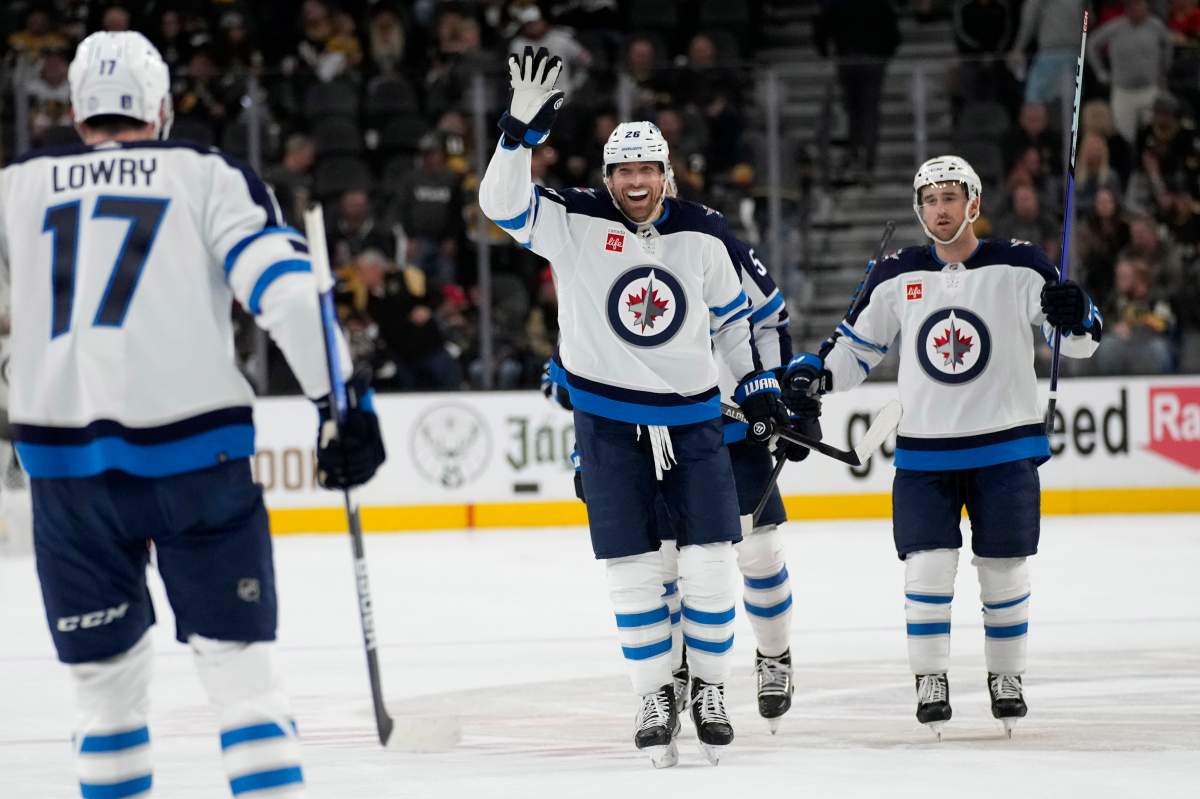 Winnipeg Jets right wing Blake Wheeler, centre, celebrates after centre Adam Lowry (17) scored against the Vegas Golden Knights during the third period of Game 1 of an NHL hockey Stanley Cup first-round playoff series Tuesday, April 18, 2023, in Las Vegas.