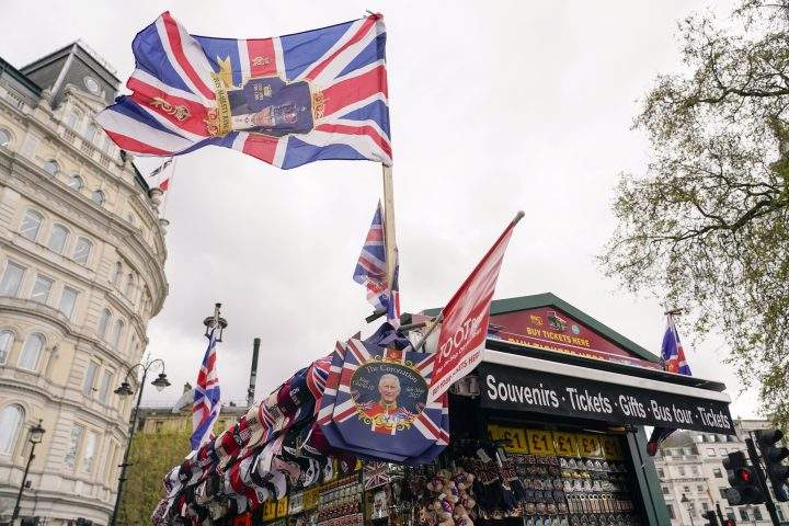 King Charles coronation memorabilia, many including Union Jack flags, on display at an outdoor stand