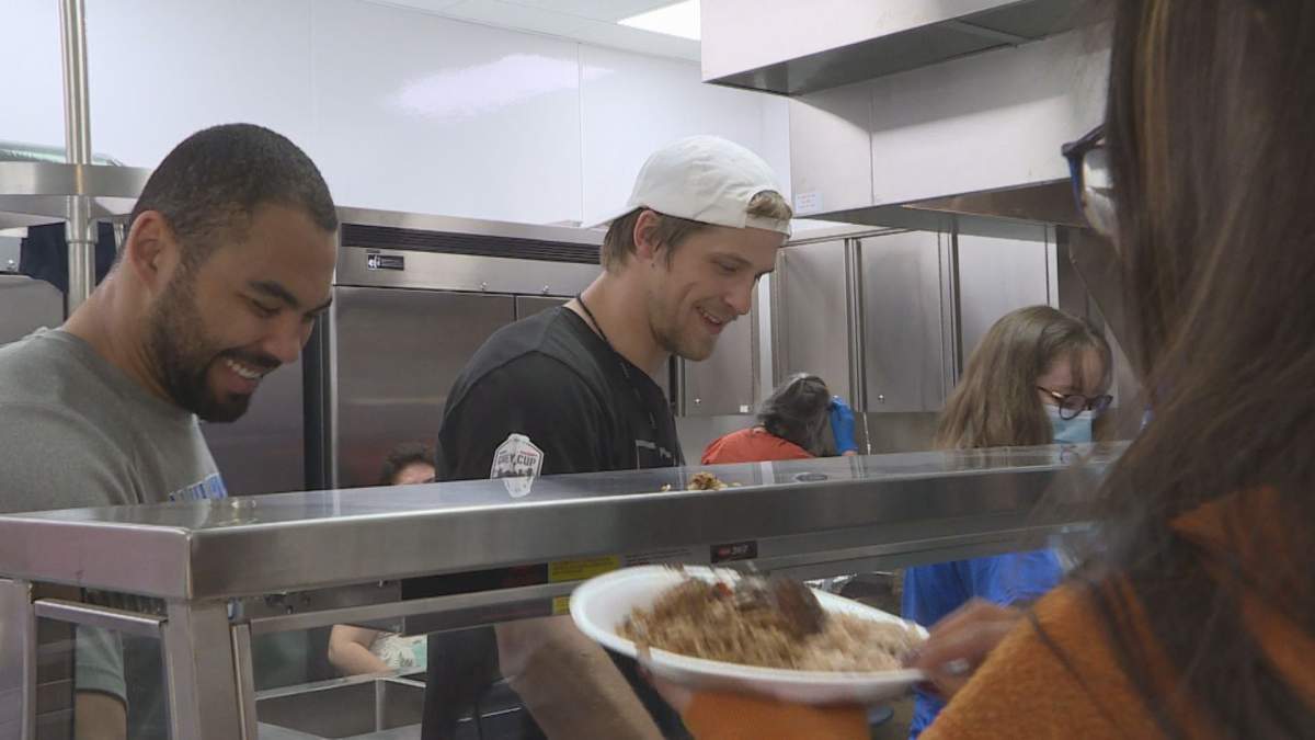 The players serving lunch to students at Bunibonibee Cree Nation.