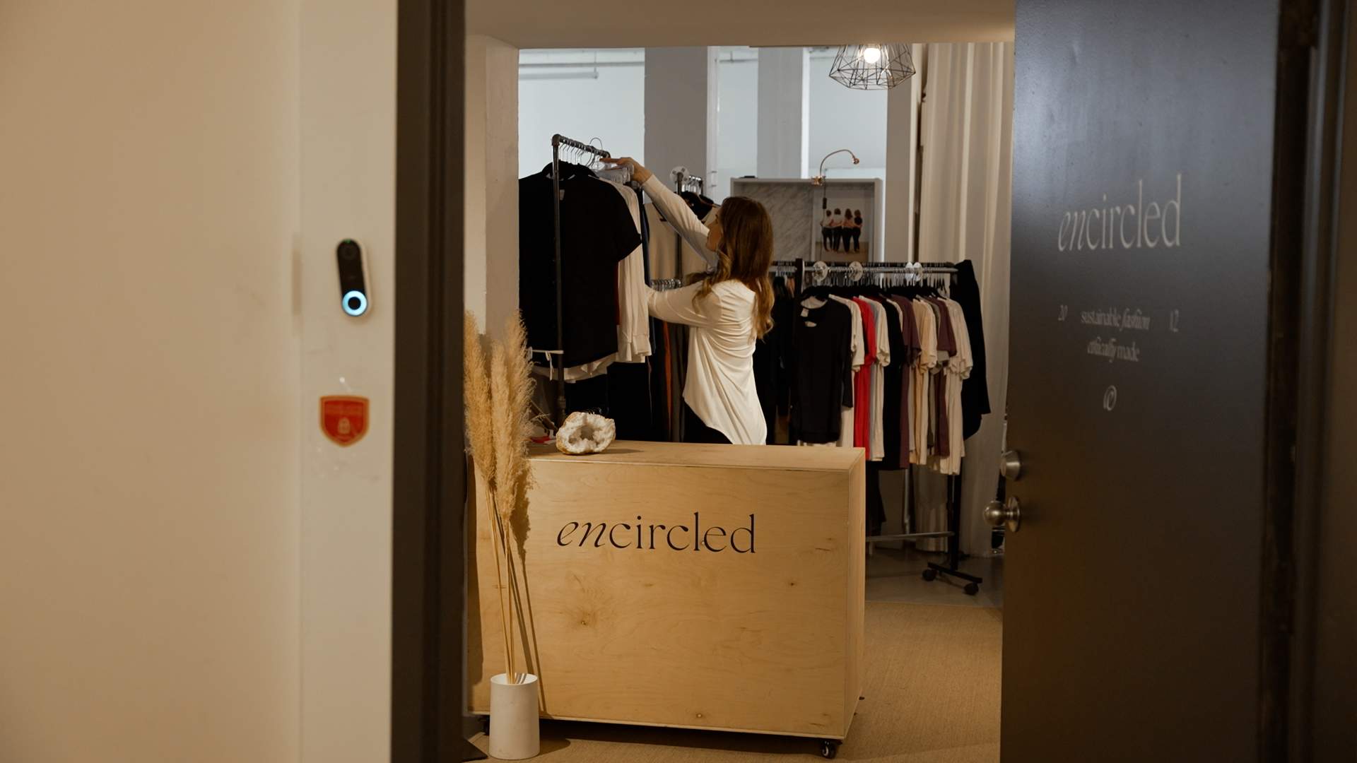 Kristi Soomer hands up an item at Encircled showroom.