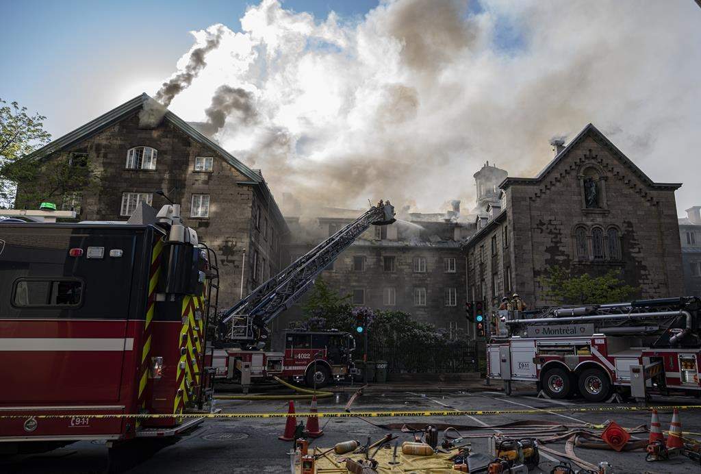 Firefighters respond to a five-alarm fire at the former Monastere du Bon Pasteur, a 19th century heritage building on Friday May 26, 2023 in Montreal.