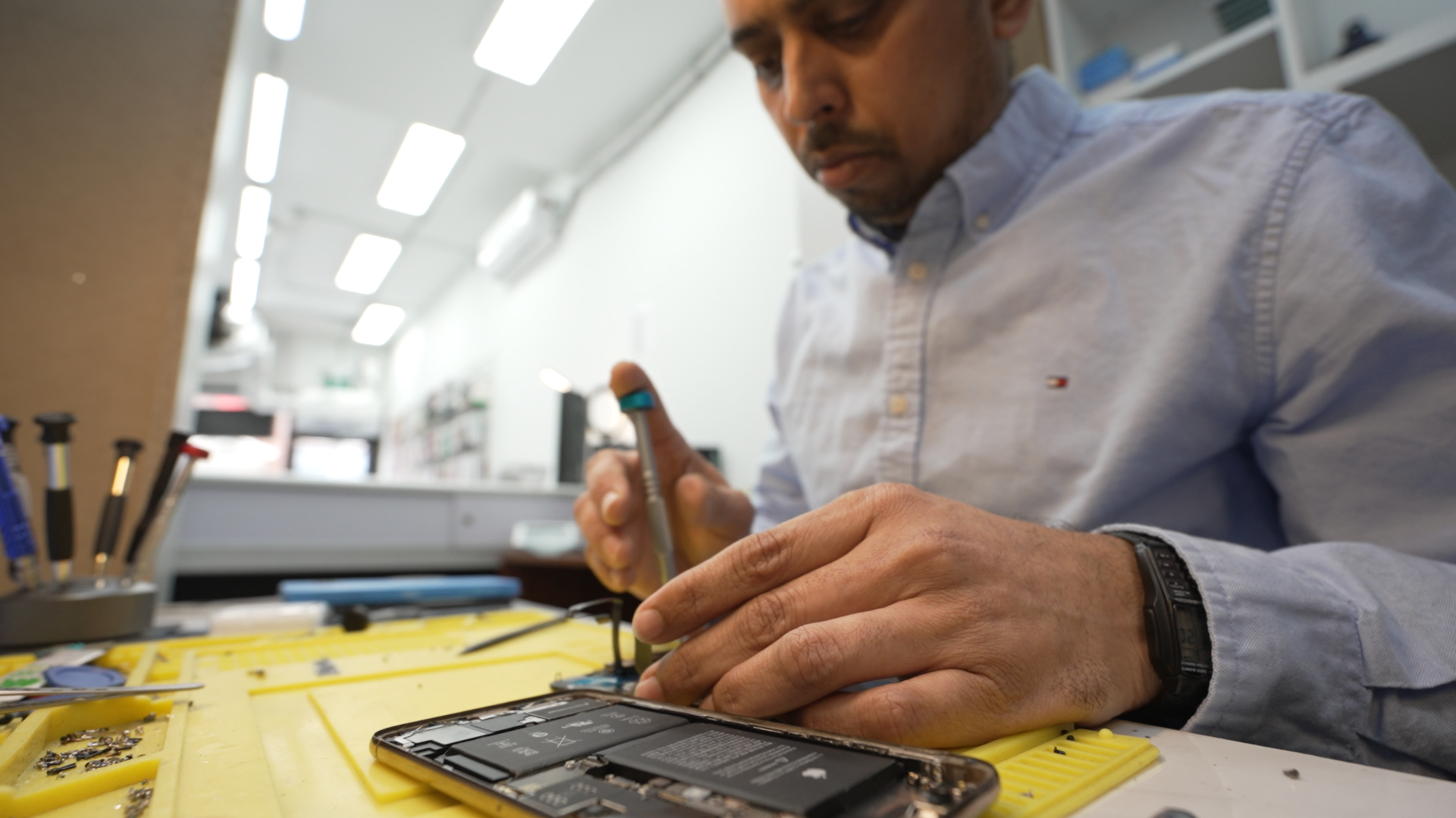 Technician Rayhan Mohammed Siraj repairs an iPhone in his shop, Phone Solutions in Toronto.
