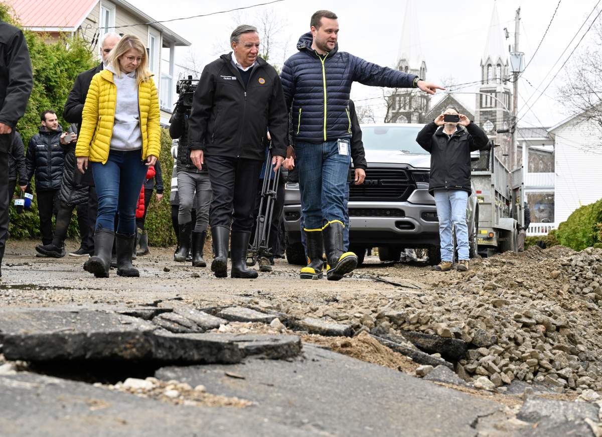 Quebec Premier Francois Legault chats with Baie-Saint-Paul mayor Michael Pilote as they tour the site of a major spring flood, Wednesday, May 3, 2023 in Baie-Saint-Paul Que. Local MNA Kariane Bourassa, left, looks on.