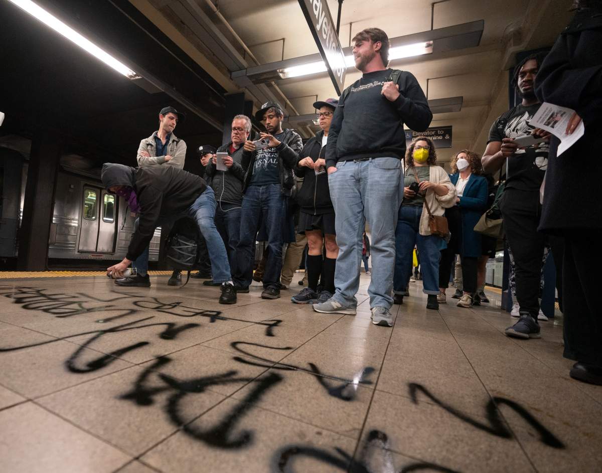 A protestor sprays graffiti on the platform during a vigil in the Broadway-Lafayette subway station on Wednesday in Manhattan, New York.