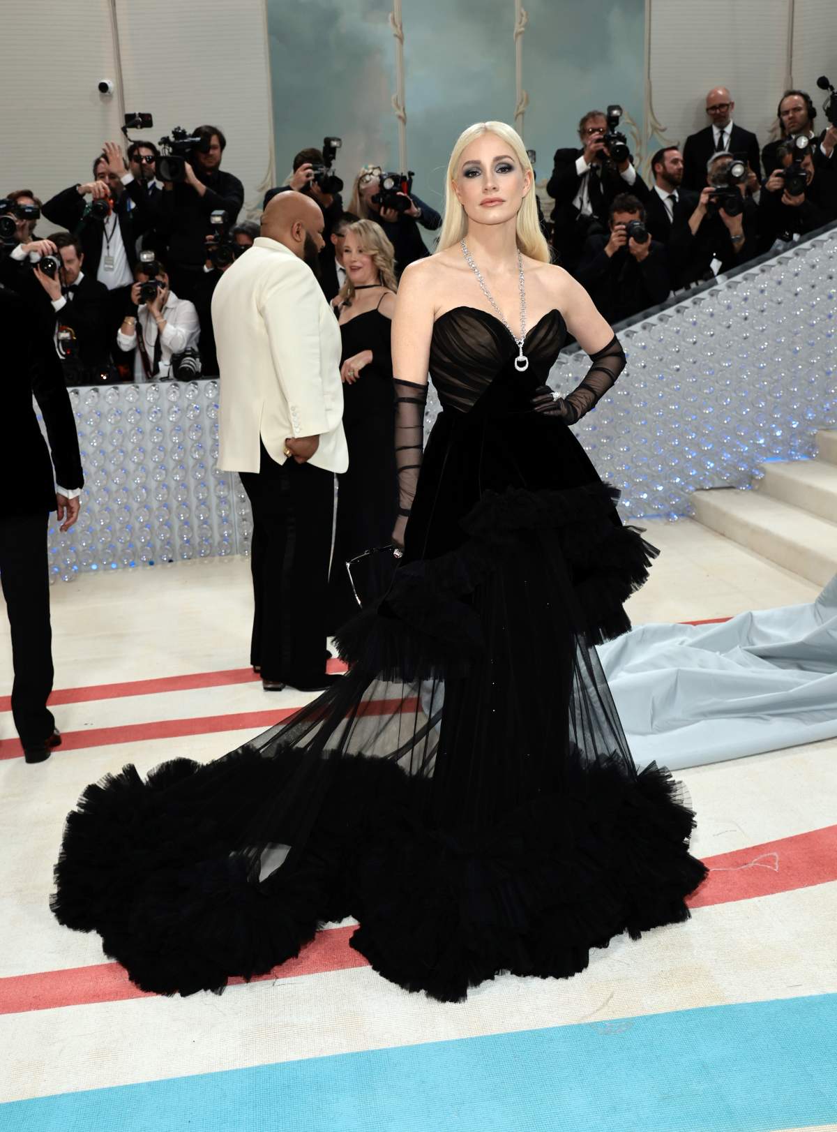 Jessica Chastain in a full-length black gown and frilly train. Parts of the train are sheer, as well as her elbow-length black gloves.
