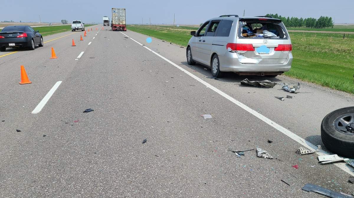 A damaged minivan and a scattered debris after a semi struck an RCMP unit during a May 19 traffic stop on Highway 2 near Stavely, Alta. (supplied: RCMP)
