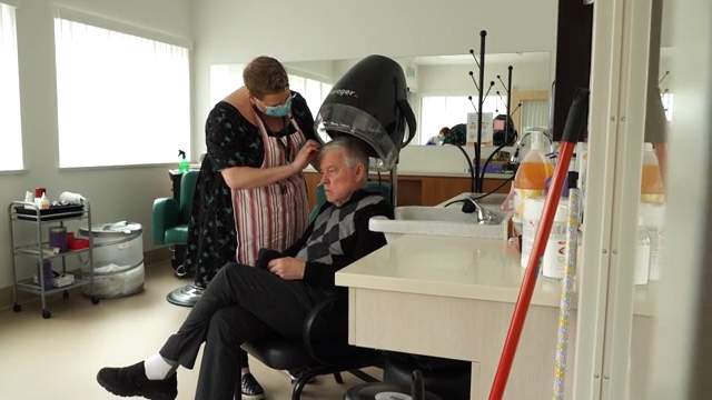 Alan, a Villager, getting his hair dried at the salon