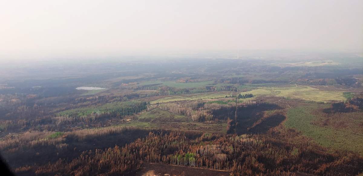 The Shiningbank Lake wildfire (EWF035) is "hopping and skipping", not burning continuously through the forest. It burns intensely in spruce stands, but slows down in aspen/poplar stands. Photo taken May 19, 2023.