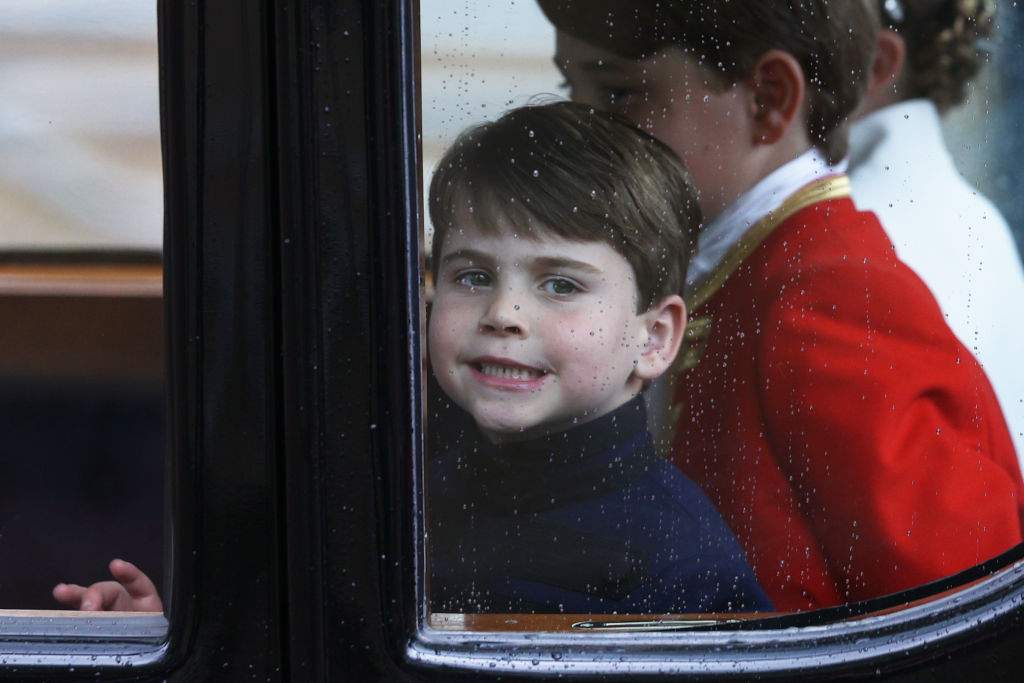 LONDON, ENGLAND – MAY 06: Prince Louis of Wales smiles through the window as he travels with his family back to Buckingham Palace from Westminster Abbey on May 6, 2023 in London, England. (Photo by Adrian Dennis – WPA Pool/Getty Images)