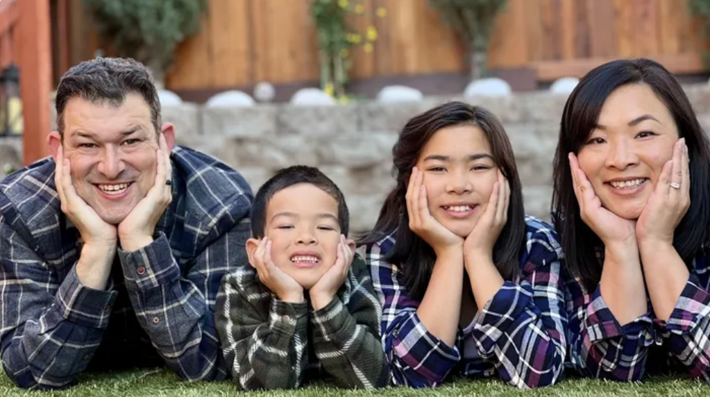 The Rivara family posing in matching plaid shirts.