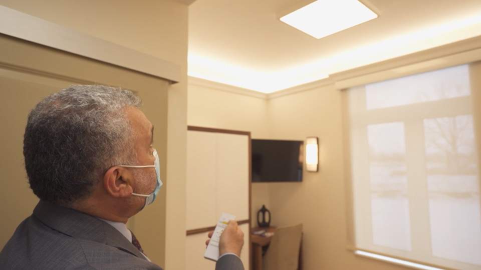 Nafia showing how biodynamic lighting works in the resident's room