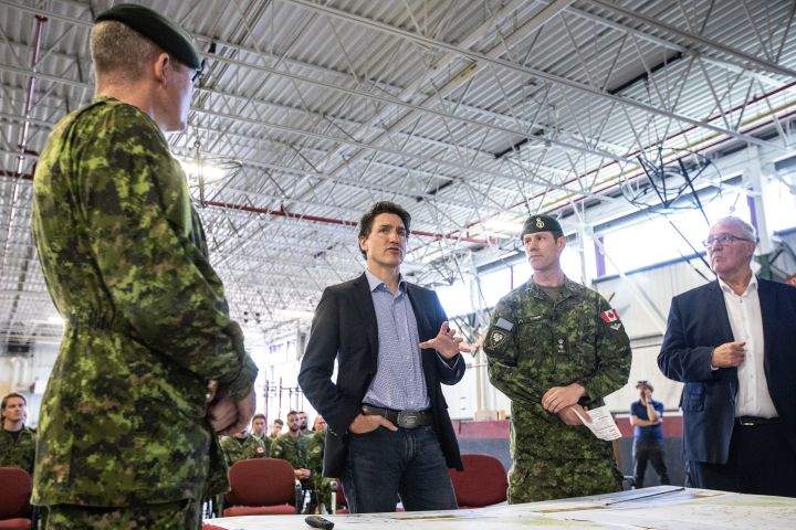 From left, General Steve Graham, Prime Minister Justin Trudeau and Colonel Ben Schmidt and Mp Bill Blair discuss the Alberta wildfires while meeting with members of the Canadian Armed Forces who are assisting in the Alberta wildfires, in Edmonton on Monday, May 15, 2023. THE CANADIAN PRESS/Jason Franson