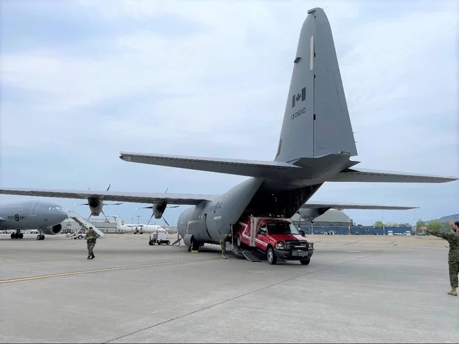 A firefighting vehicle being unloaded from a Canadian Armed Forces Hercules plane at the Fort Chipewyan airport on June 4, 2023.
