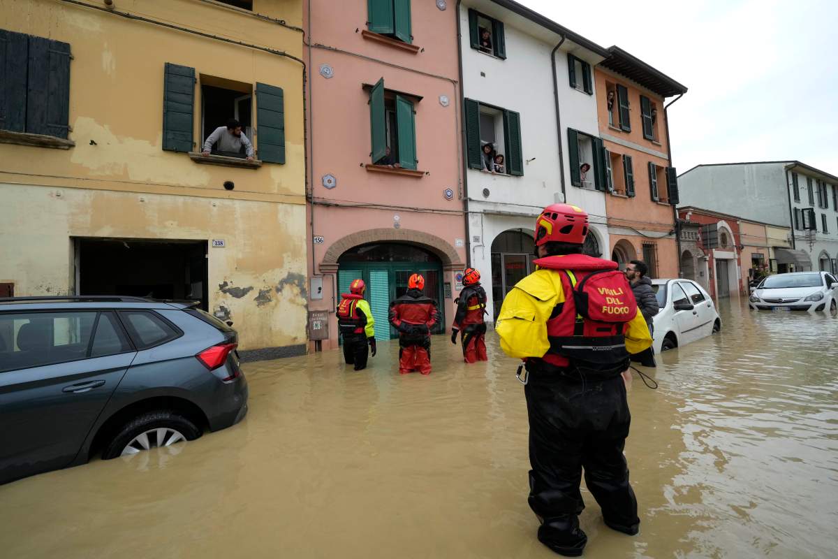 Firefighters talks with residents of the flooded village of Castel Bolognese, Italy, Wednesday, May 17, 2023.