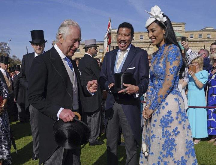Britain’s King Charles III, left, reacts with U.S. singer Lionel Richie and Lisa Parigi, during a garden party at Buckingham Palace, London, Wednesday, May 3, 2023, in celebration of the coronation on May 6.