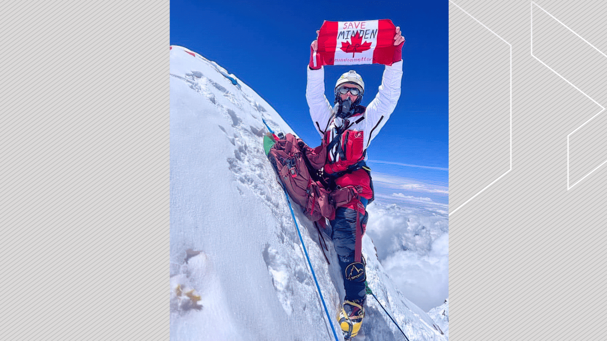 Liliya Ianovskaia unfolds a Canadian flag with "Save Minden ER" atop Lhotse in Nepal on May, 24, 2023.