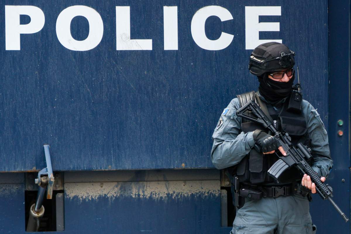 A Kosovo police officer guards a municipal building after Friday’s violent clashes between police and ethnic Serbs, in the town of Zvecan, northern Kosovo, last Sunday.  (AP Photo/Marjan Vucetic)