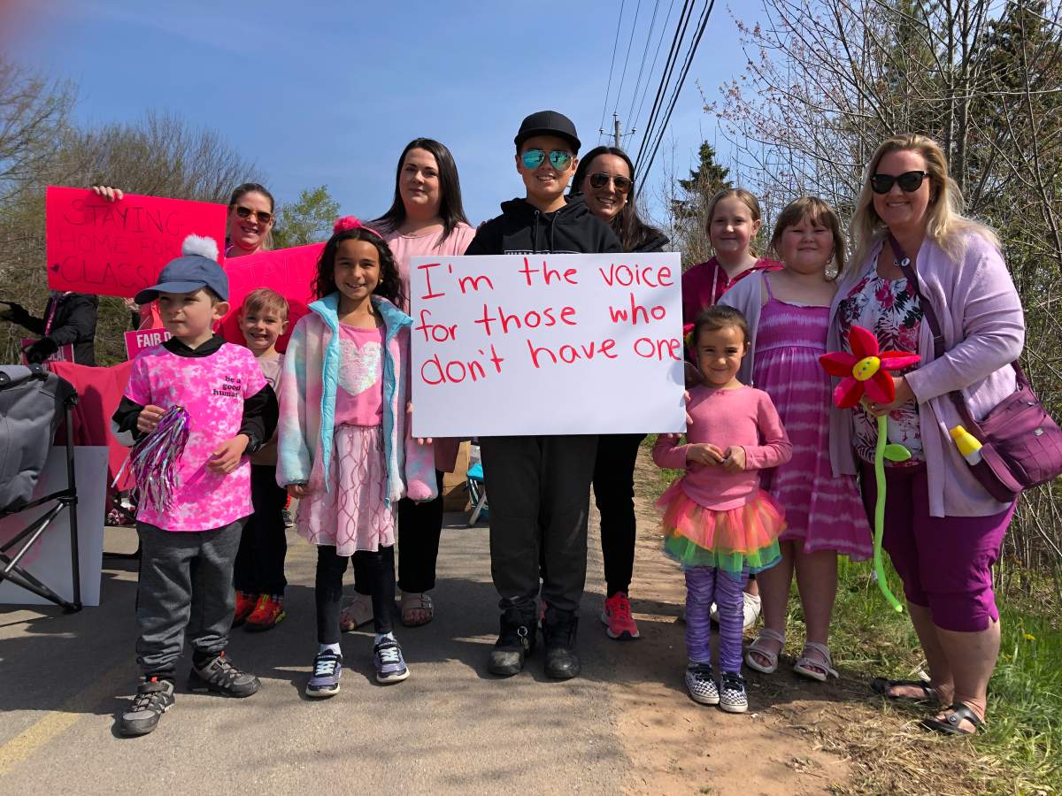 Grade 6 student Thane Day (center) skips school to support striking workers. He’s joined by the solidarity day organizer Teagan Archer-Perrell, who stands to his right.