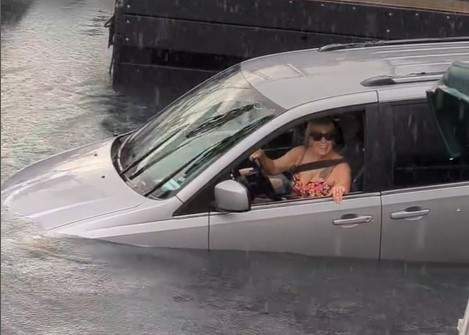 The driver smiles and appears to be unaware of what's happening at first.