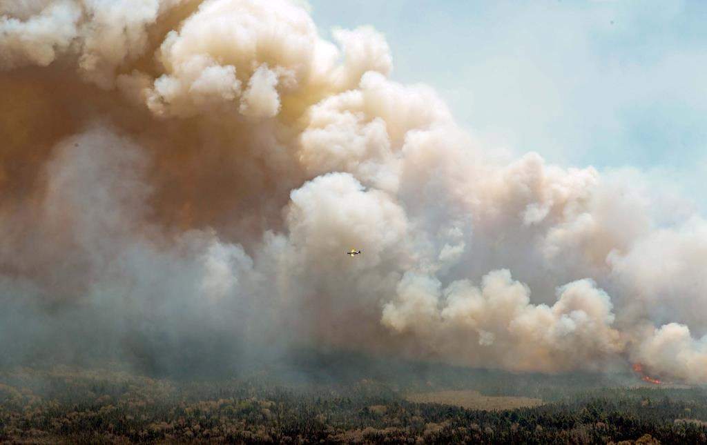 An aircraft (centre) disperses a mix of water and fire retardant over a fire near Barrington Lake in Shelburne County, N.S. in this Wednesday, May 31, 2023 handout photo. The fires plaguing residents in Alberta and Nova Scotia are part of a larger trend that’s driving up the cost of home insurance as extreme weather becomes more common, insurance experts said. THE CANADIAN PRESS/HO-Communications Nova Scotia **MANDATORY CREDIT**