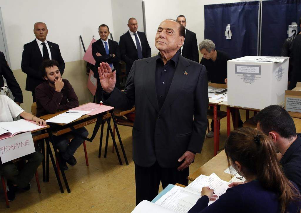 FILE – Former Italian Premier Silvio Berlusconi waves to photographers as he arrives to vote for the European Parliament elections at a polling station in Milan, Italy, on May 26, 2019.