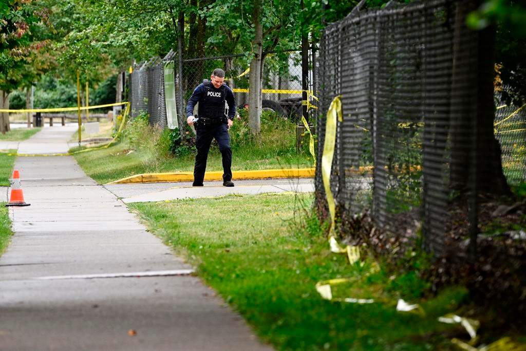 A police officer surveys the scene near the Guru Nanak Sikh Gurdwara Sahib temple after a shooting in Surrey, B.C., Mon. June 19, 2023.