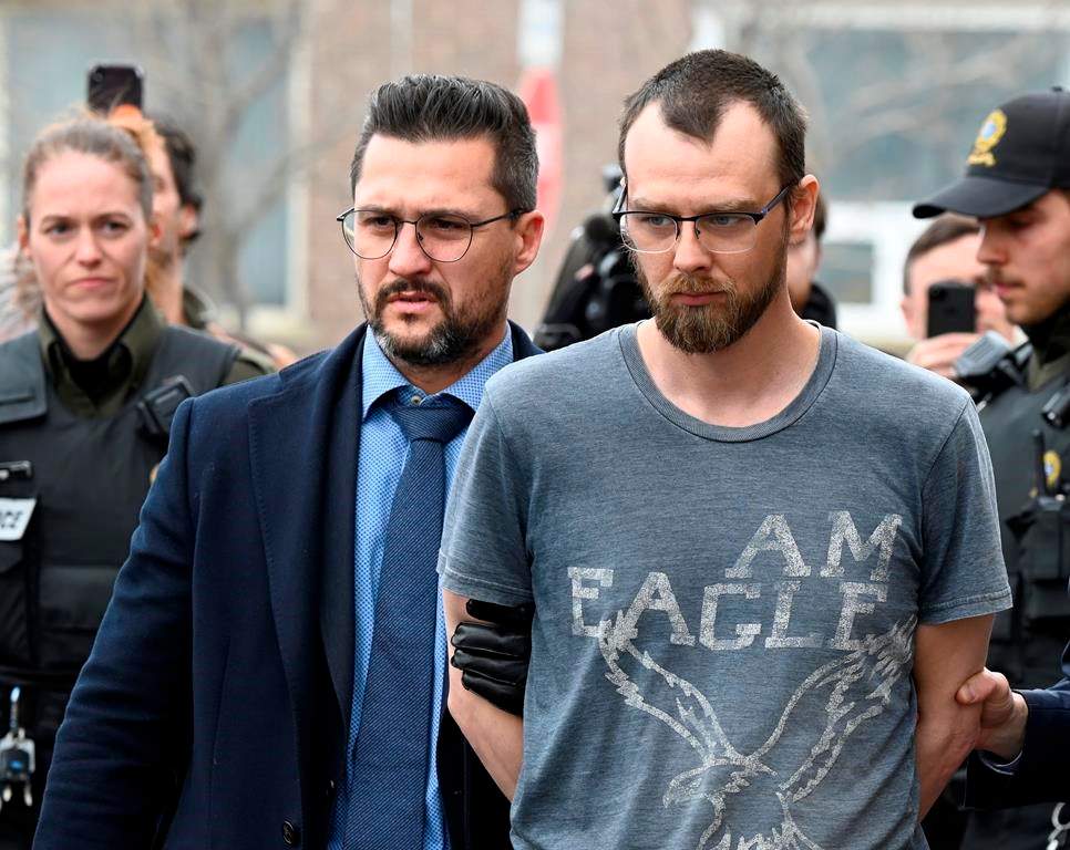 Steeve Gagnon is escorted by police out of court in Amqui, Que., Tuesday, March 14, 2023. Gagnon, a Quebec man accused of deliberately driving his truck into pedestrians in March, will have a preliminary hearing in September. THE CANADIAN PRESS/Jacques Boissinot.