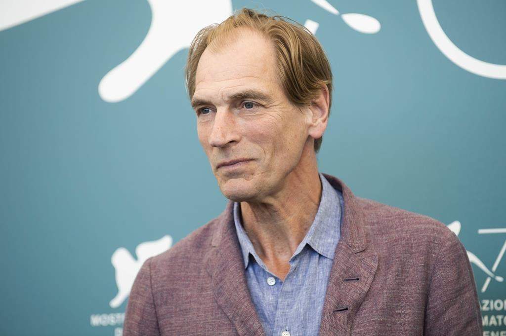 FILE - Actor Julian Sands poses for photographers at the Venice Film Festival in Venice, Italy, on Sept. 3, 2019.