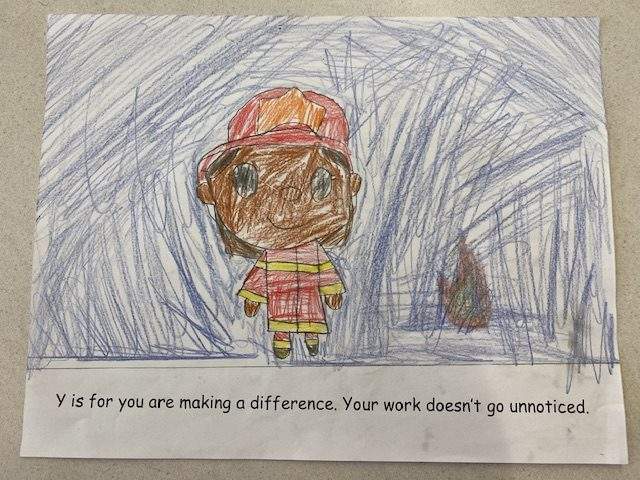 "Y is for you are making a difference. Your work doesn't go unnoticed." read another page of the booklet, accompanied by a student's drawing of a firefighter.