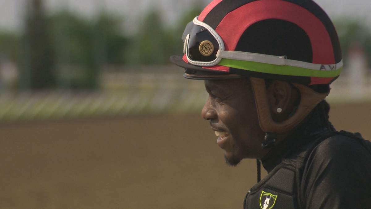 Antonio Whitehall watches his fellow riders running their horses.